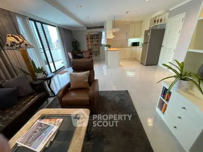 Spacious open-layout living room with modern kitchen and balcony view in a high-rise apartment.