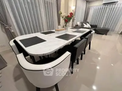 Elegant dining area with marble table and modern decor in a spacious living room.