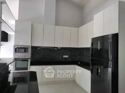 Modern kitchen with sleek black appliances and white cabinetry