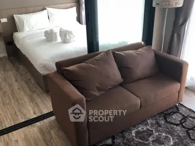 Cozy bedroom with brown sofa and elegant decor in modern apartment.