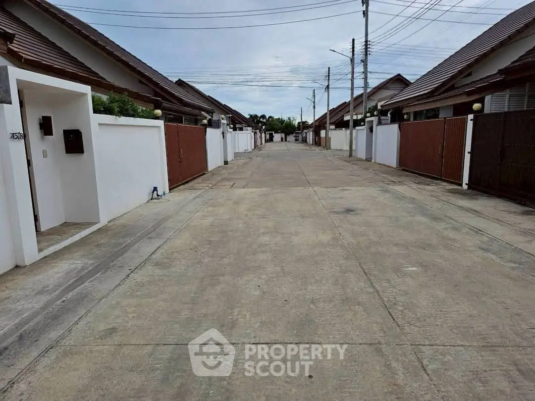 Charming residential street with modern houses and spacious driveways in a serene neighborhood.