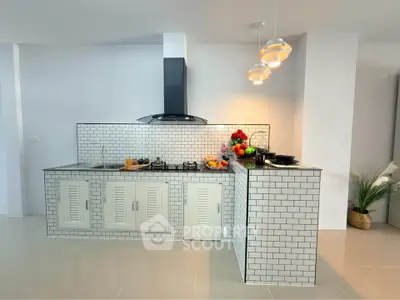 Modern kitchen with sleek white tile backsplash and gas stove, perfect for culinary enthusiasts.