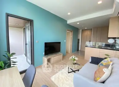 Modern living room with stylish decor and open layout, featuring a cozy sofa and flat-screen TV.