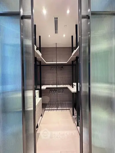 Luxurious walk-in closet with sleek shelving and modern lighting in upscale home.