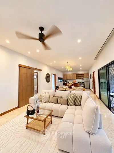 Spacious modern living room with cozy sectional sofa and open kitchen layout, perfect for entertaining.