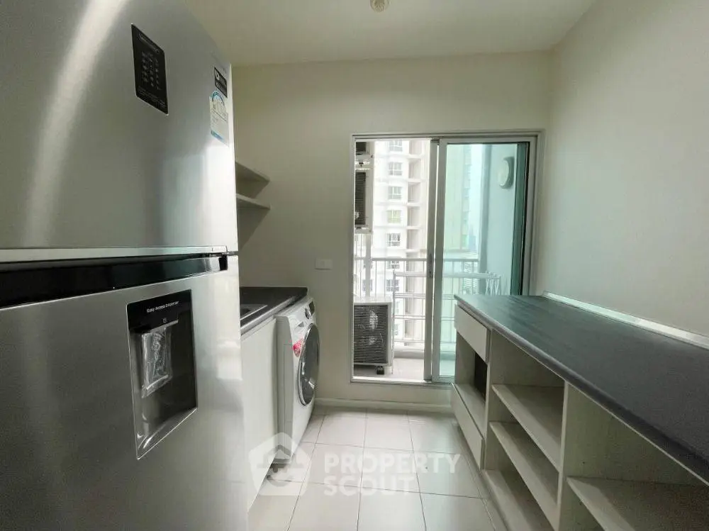 Modern kitchen with sleek appliances and ample storage space in a high-rise apartment.