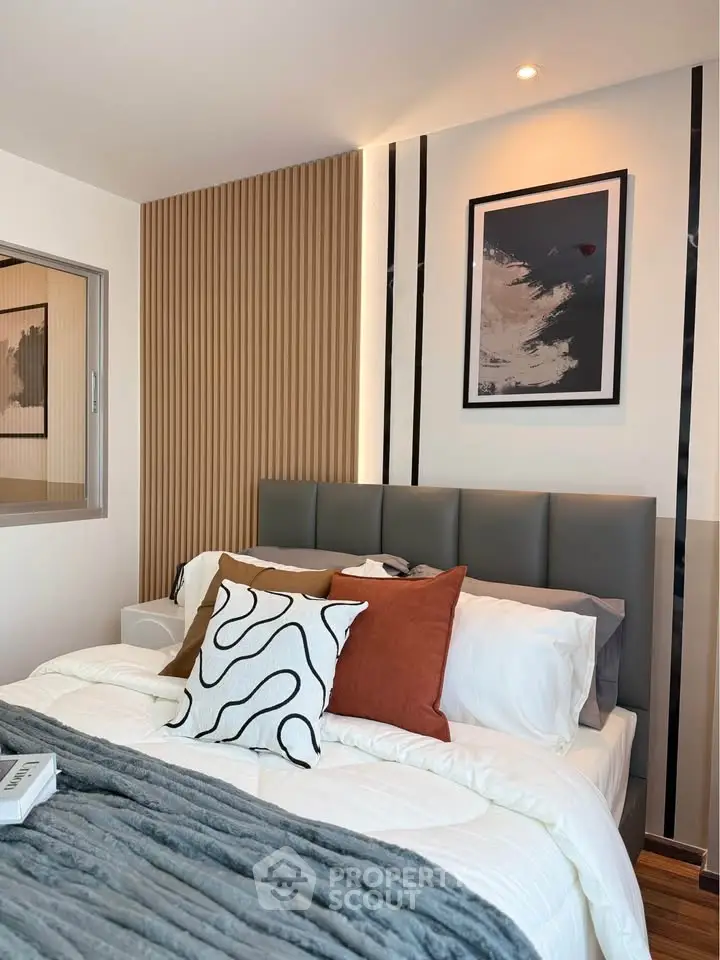 Modern bedroom with stylish decor and cozy bedding in a contemporary apartment.