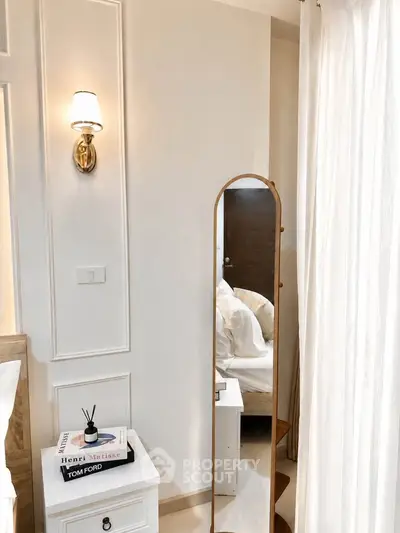 Elegant bedroom with stylish decor, featuring a full-length mirror and chic bedside table.