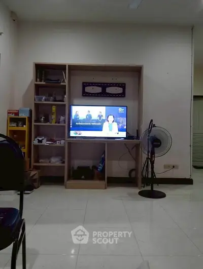 Cozy living room with TV and fan, perfect for relaxation and entertainment.