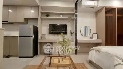 Modern studio apartment with sleek kitchen and cozy living area, featuring stylish decor and efficient use of space.