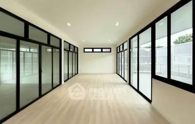 Spacious modern room with large windows and sleek design, perfect for versatile living or office space.