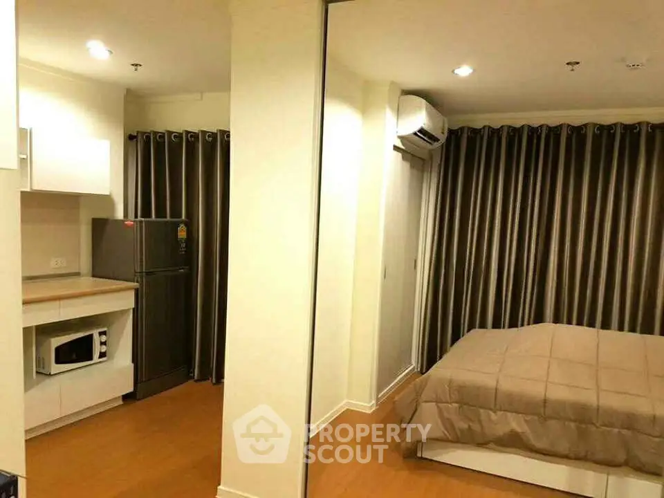 Cozy studio apartment with modern kitchen and comfortable bedroom area, perfect for urban living.