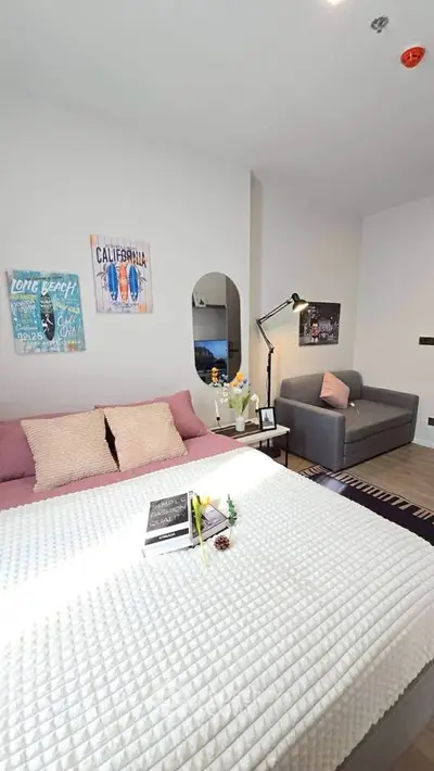 Modern bedroom with stylish decor and cozy seating area, perfect for relaxation and comfort.