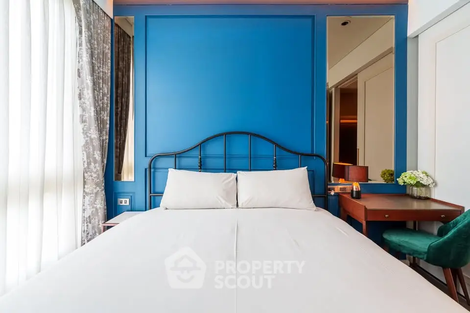 Elegant bedroom with blue accent wall and stylish furnishings