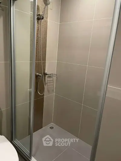 Modern bathroom with sleek shower enclosure and neutral tiles