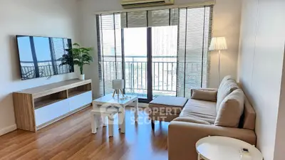 Modern living room with large windows and stylish furniture in a high-rise apartment.