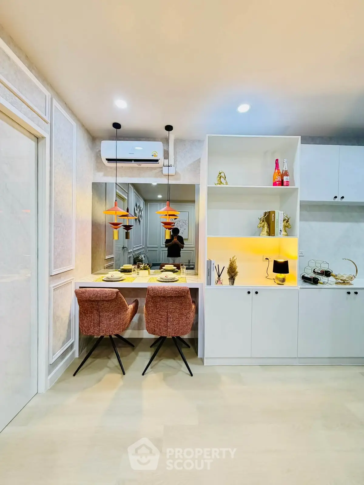 Modern kitchen with stylish dining area and open shelving, featuring elegant lighting and contemporary decor.