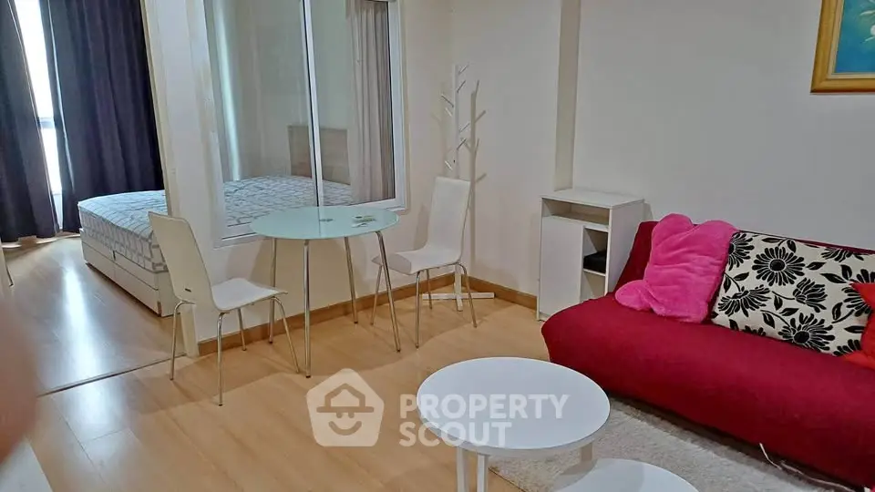Modern studio apartment with cozy living area and bedroom, featuring stylish furniture and natural light.