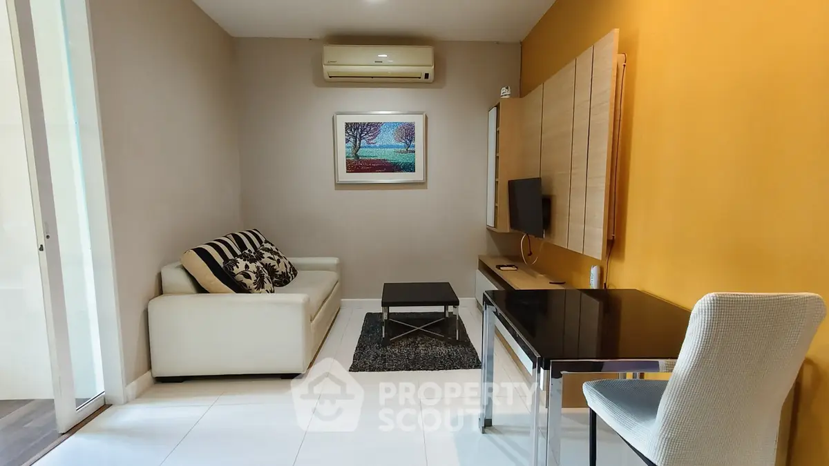 Modern living room with stylish decor, featuring a cozy sofa, wall-mounted TV, and elegant workspace.