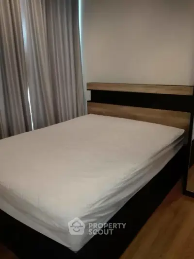 Cozy bedroom with modern bed and elegant curtains, perfect for restful nights.