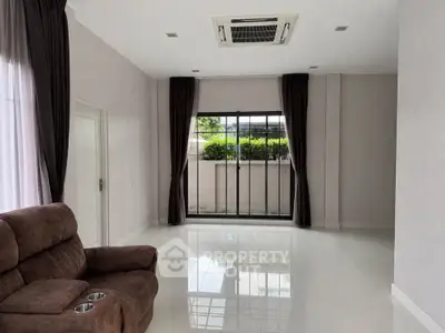 Spacious living room with modern air conditioning and large windows for natural light.