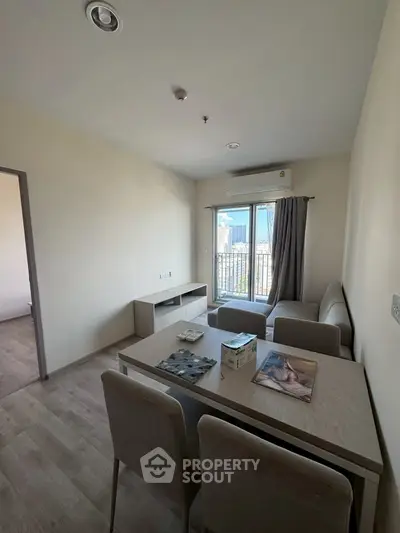 Modern living room with dining table and city view from window.