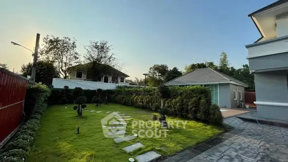 Charming garden view with modern house and lush greenery, perfect for serene living.
