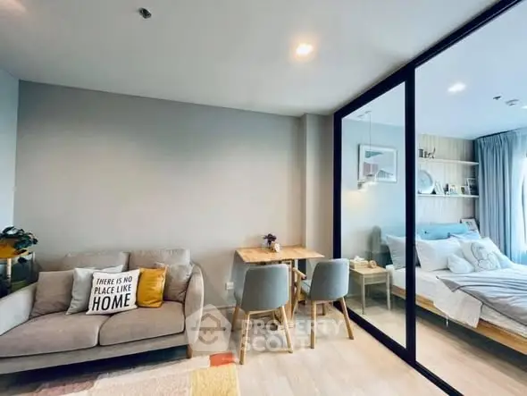 Modern open-plan living room with cozy seating and dining area, adjacent to a stylish bedroom.