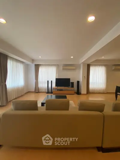 Spacious living room with modern decor and ample natural light