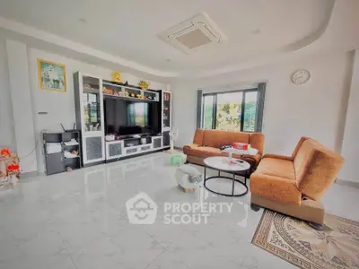 Spacious living room with modern furniture and large TV, perfect for family gatherings.