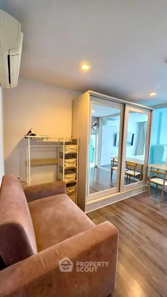 Modern living room with mirrored wardrobe and cozy sofa in stylish apartment.