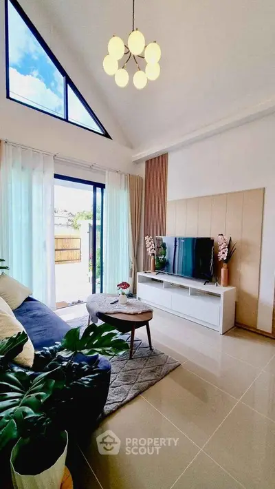 Elegant living room with high ceiling, modern decor, and large windows for natural light.
