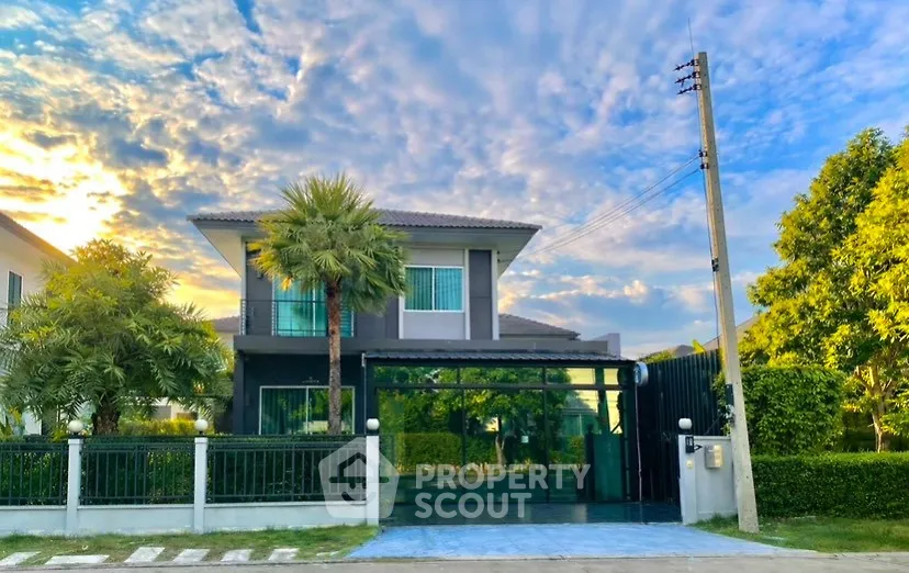 Stunning modern two-story house with lush greenery and vibrant sky backdrop.