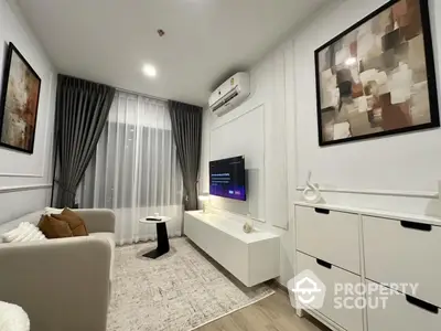 Modern living room with stylish decor, featuring a cozy sofa, wall-mounted TV, and elegant artwork.