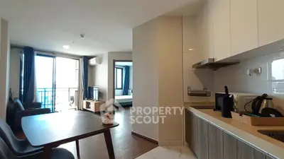 Modern open-layout apartment with kitchen and living area, featuring sleek furniture and a bright, airy ambiance.