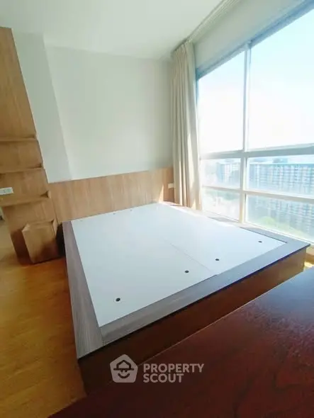 Spacious bedroom with large windows offering stunning city views