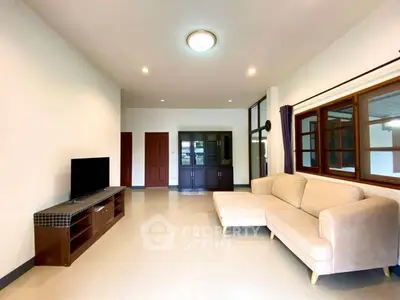 Spacious living room with modern sofa and entertainment unit, ideal for relaxation and gatherings.