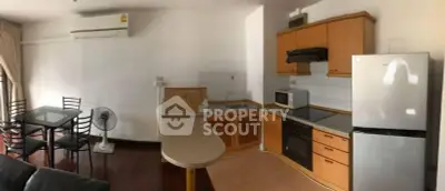 Spacious kitchen with modern appliances and dining area in open layout apartment.