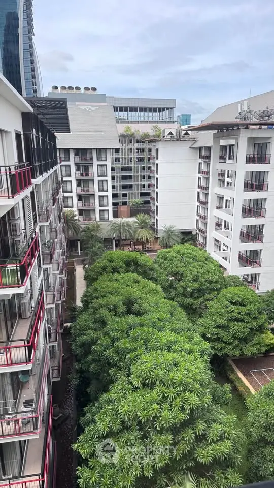 Stunning view of modern apartment complex with lush greenery and cityscape backdrop.