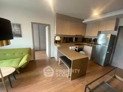 Modern open-layout kitchen and living room with sleek design and stylish furniture.