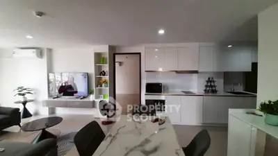 Modern open-plan living room with sleek kitchen and marble dining table