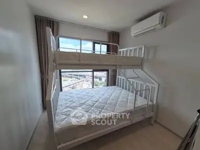 Cozy bedroom with bunk bed and city view, perfect for small families or roommates.