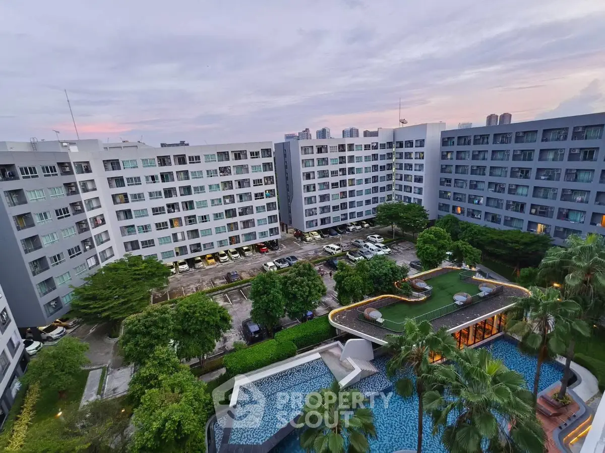 Modern apartment complex with pool and lush greenery, offering urban living with resort-style amenities.