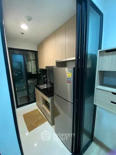 Modern kitchen with sleek design and stainless steel appliances in a compact layout.