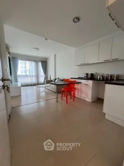 Spacious open-plan living room with modern kitchen and bright natural light.