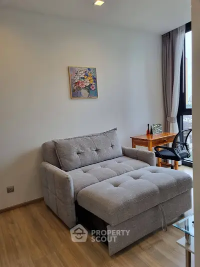 Cozy living room with modern sofa bed and study desk, perfect for urban living.