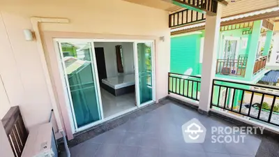 Spacious balcony with sliding glass doors overlooking modern residential area.