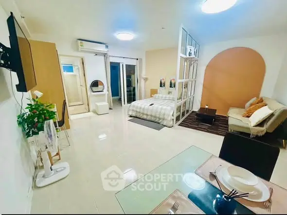 Spacious studio apartment with modern decor and open layout, featuring cozy living area and dining space.