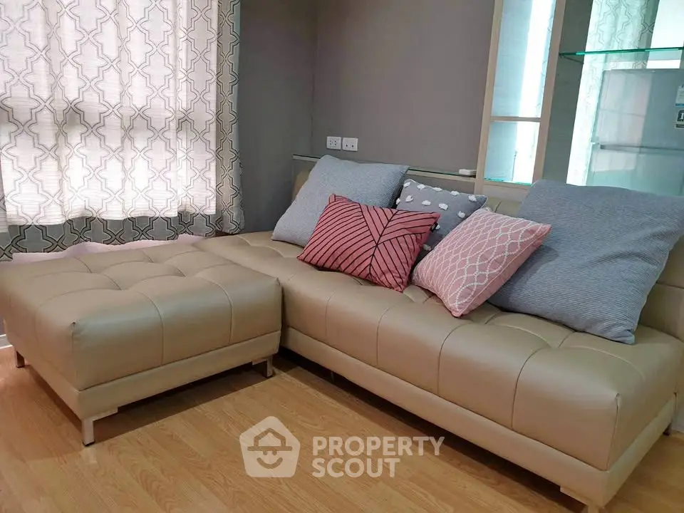 Stylish living room with modern beige sectional sofa and decorative pillows, perfect for cozy relaxation.