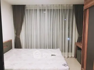 Cozy bedroom with large window and elegant curtains, featuring a comfortable bed and wooden furniture.
